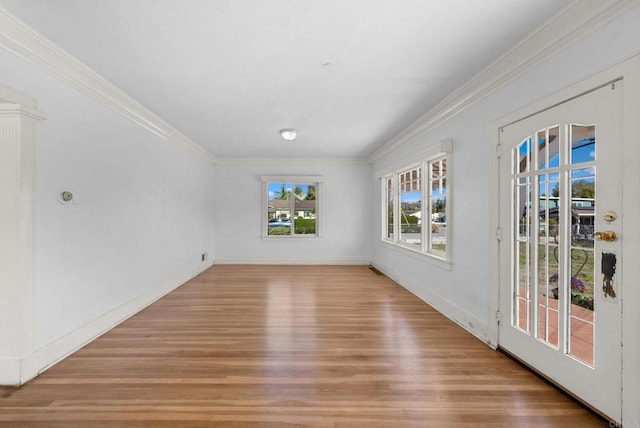 unfurnished room featuring ornamental molding, baseboards, and light wood finished floors