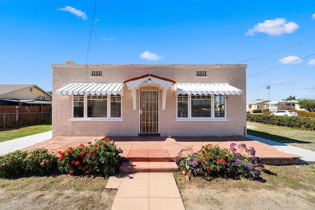 view of front of home with fence and stucco siding