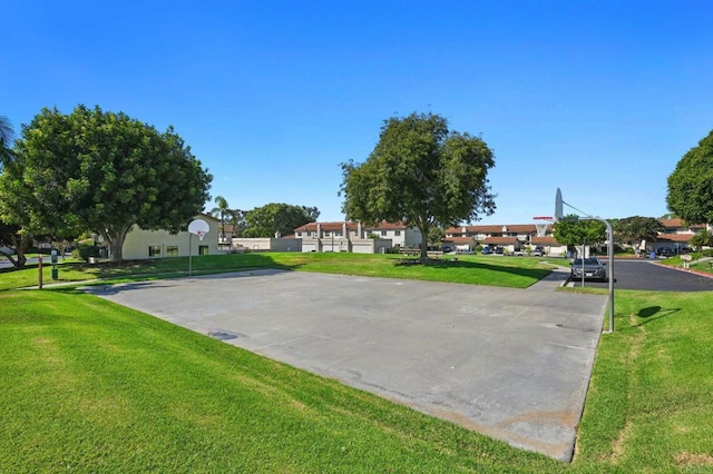 exterior space featuring a lawn and community basketball court