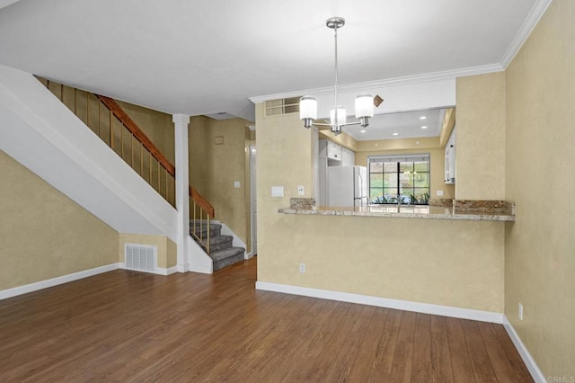 kitchen with visible vents, baseboards, wood finished floors, and freestanding refrigerator