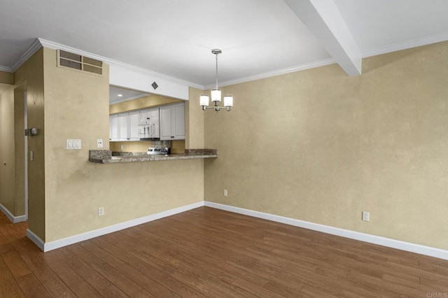 kitchen featuring visible vents, dark wood-type flooring, white microwave, and baseboards