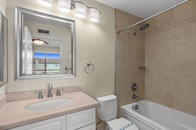 full bathroom featuring visible vents, toilet, shower / bath combination, vanity, and a textured wall