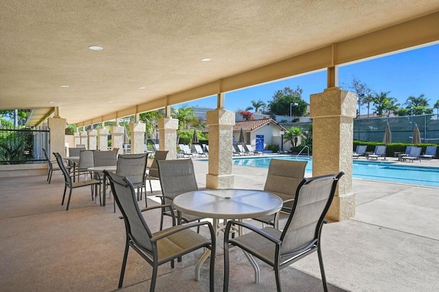 view of patio / terrace with a community pool and fence