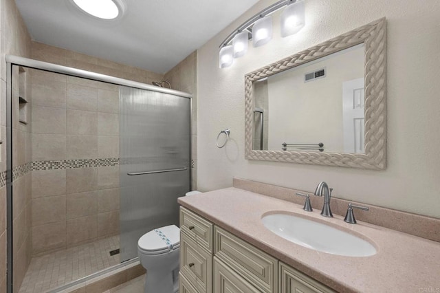 bathroom featuring visible vents, vanity, toilet, and a shower stall