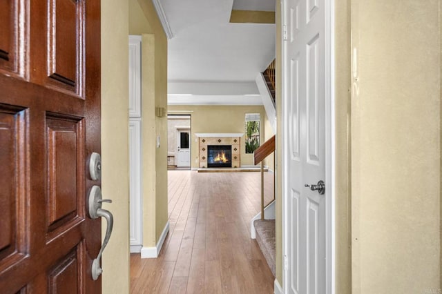 foyer featuring hardwood / wood-style floors, stairs, a fireplace, and baseboards