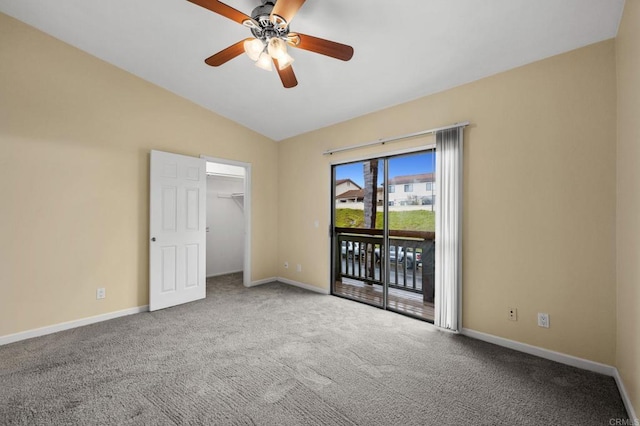 unfurnished bedroom featuring lofted ceiling, access to outside, carpet floors, baseboards, and a spacious closet