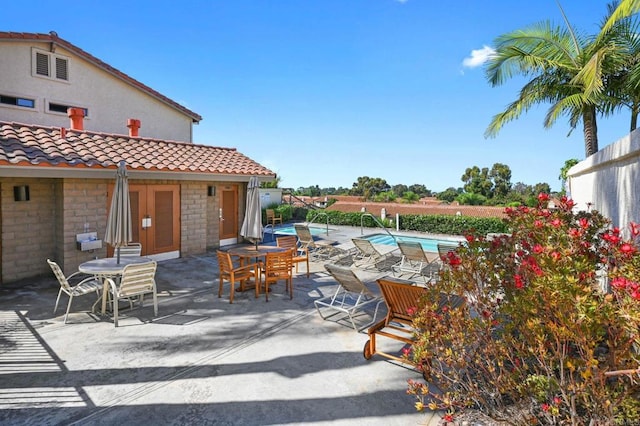 view of patio with outdoor dining space and a fenced in pool