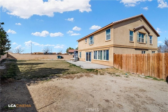 rear view of property with a patio area, a fenced backyard, and stucco siding