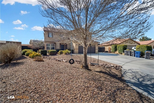 view of front of property featuring an attached garage, concrete driveway, and stucco siding