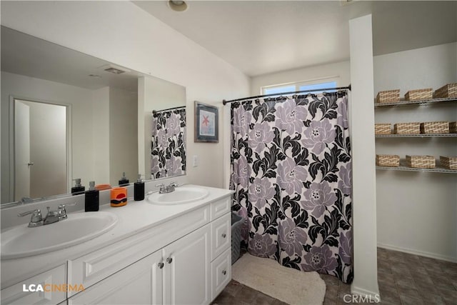 bathroom with double vanity, a sink, and visible vents