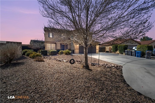 view of front of home with a garage, concrete driveway, and stucco siding