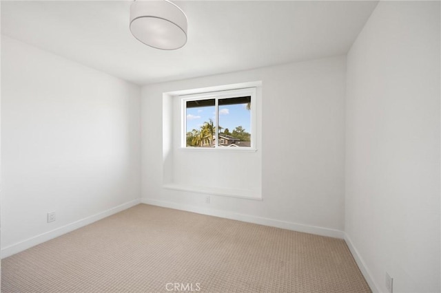 carpeted spare room featuring baseboards