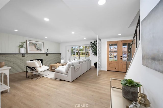 living room featuring light wood-style floors, recessed lighting, and stairway