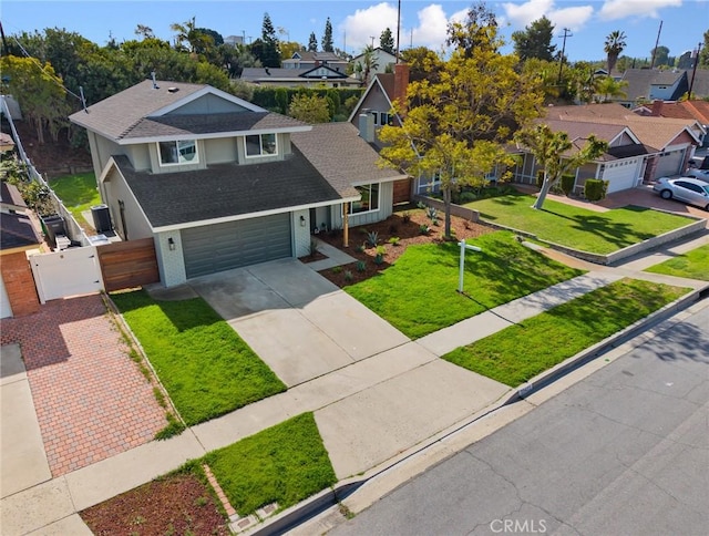 view of front of home featuring a front yard, a gate, fence, a residential view, and driveway