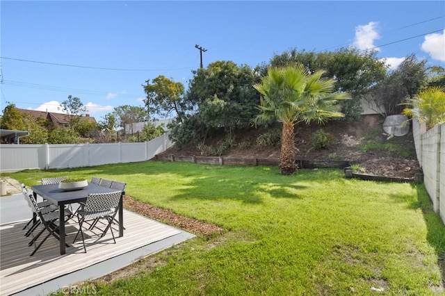 view of yard with a fenced backyard, a deck, and outdoor dining space