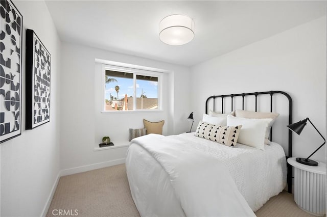 bedroom with light carpet and baseboards