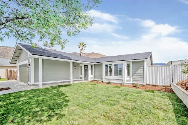 ranch-style home with a garage, concrete driveway, a front lawn, and fence