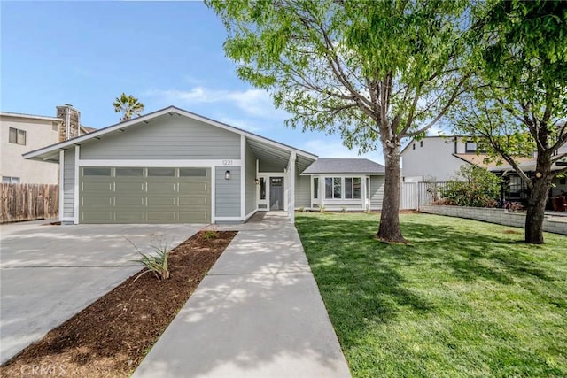 view of front facade with a garage, driveway, a front yard, and fence