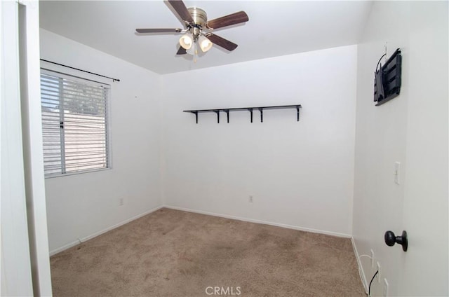 spare room with baseboards, a ceiling fan, and light colored carpet