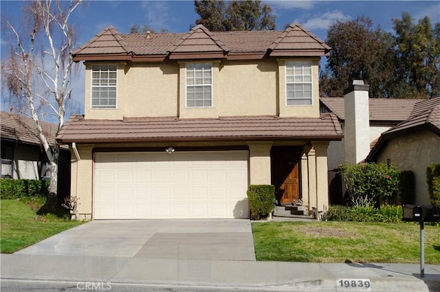 view of front facade with a tile roof, stucco siding, concrete driveway, a garage, and a front lawn