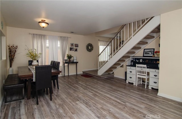 dining area with visible vents, stairway, baseboards, and wood finished floors