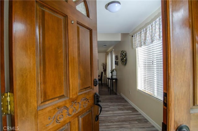 hall with baseboards and wood finished floors