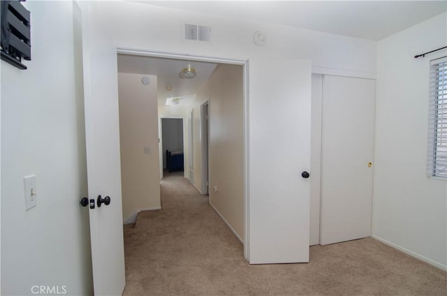 hallway with light colored carpet and visible vents