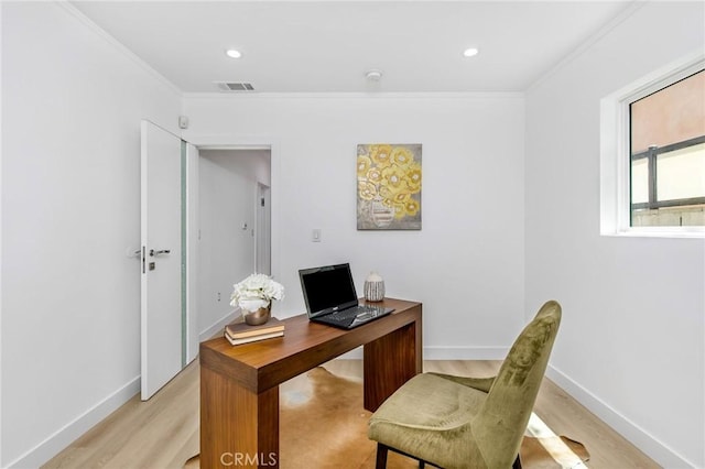 home office featuring light wood finished floors, visible vents, ornamental molding, and baseboards