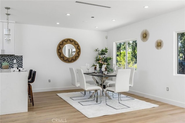dining room featuring baseboards, light wood finished floors, and recessed lighting
