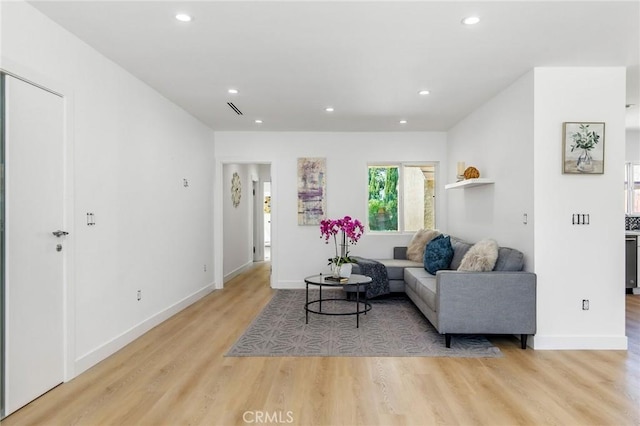 living room with light wood-type flooring, baseboards, and recessed lighting