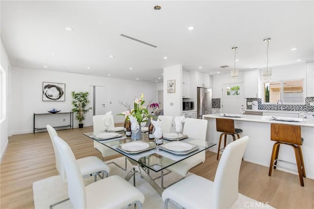 dining area with recessed lighting and light wood-style floors