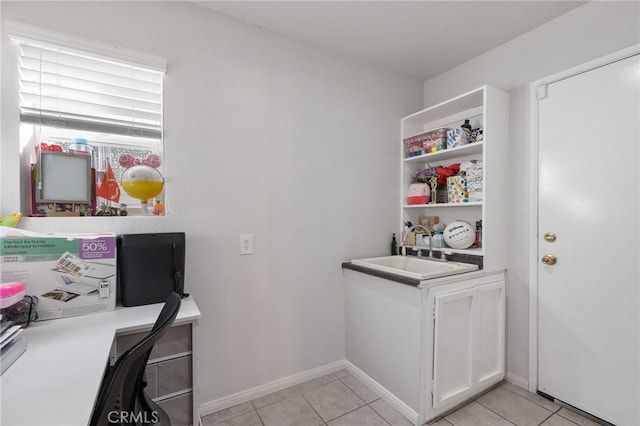 office area featuring light tile patterned floors, a sink, and baseboards