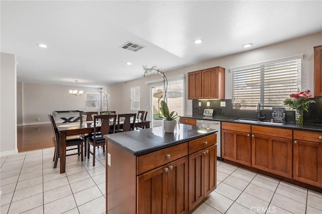 kitchen with dark countertops, light tile patterned floors, visible vents, and stainless steel dishwasher