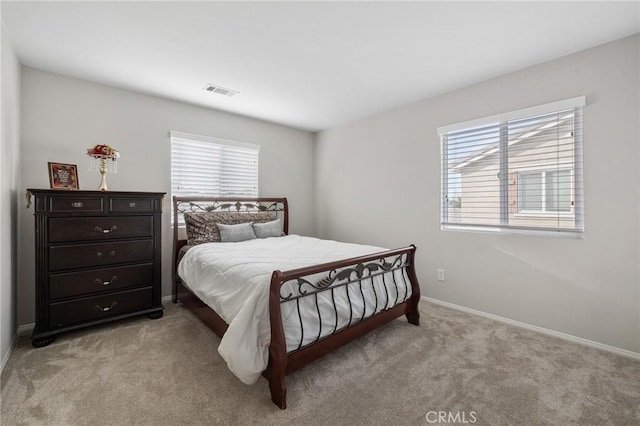 bedroom featuring light colored carpet, visible vents, and multiple windows