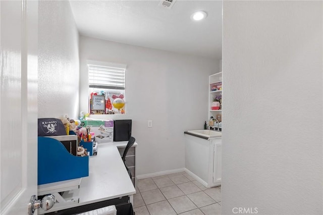 office space featuring light tile patterned floors, a sink, visible vents, and baseboards