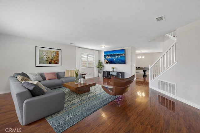 living area featuring stairs, visible vents, a chandelier, and wood finished floors