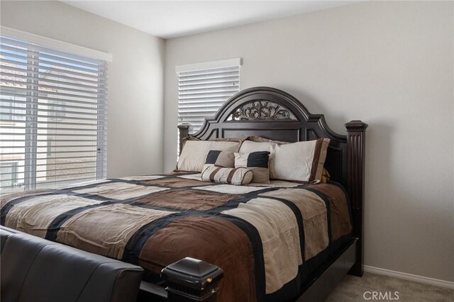 bedroom featuring multiple windows, carpet, and baseboards