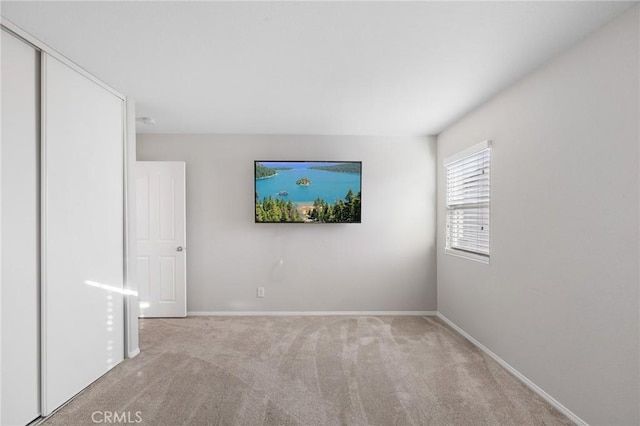 unfurnished room featuring carpet floors and baseboards