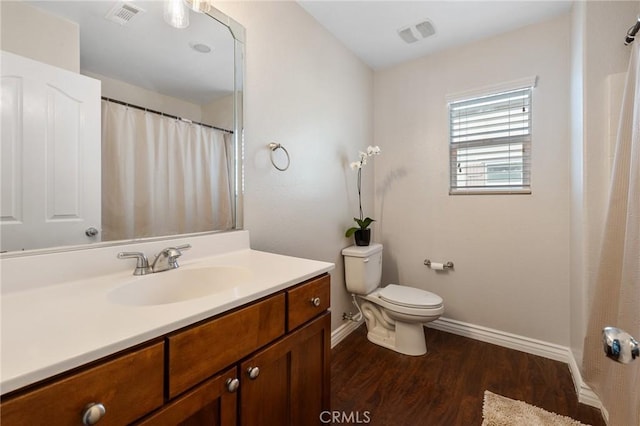 full bath featuring baseboards, visible vents, toilet, and wood finished floors