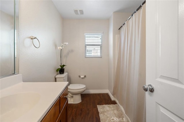 full bathroom featuring visible vents, baseboards, toilet, wood finished floors, and vanity