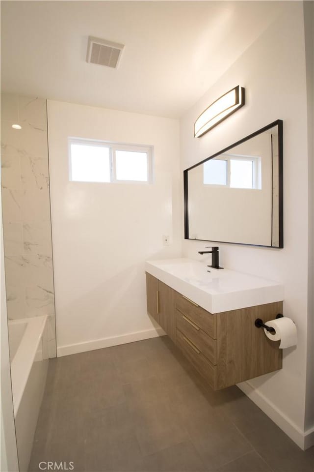 full bathroom with visible vents, vanity, baseboards, and a bath