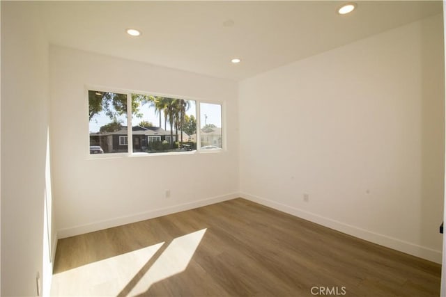 unfurnished room featuring recessed lighting, baseboards, and wood finished floors