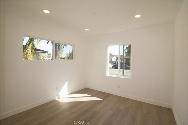 spare room featuring baseboards, wood finished floors, and recessed lighting