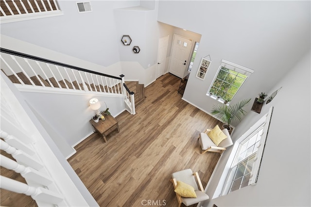 interior space with a high ceiling, wood finished floors, and visible vents