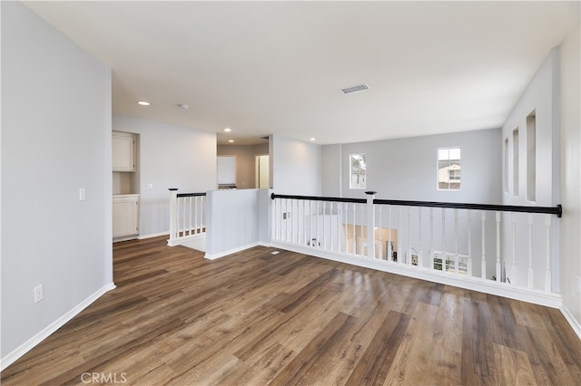 empty room with recessed lighting, visible vents, baseboards, and wood finished floors