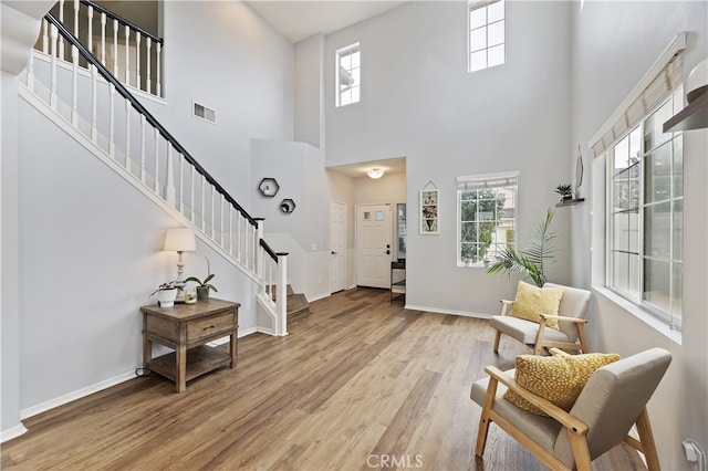 entryway with light wood finished floors, stairway, plenty of natural light, and baseboards