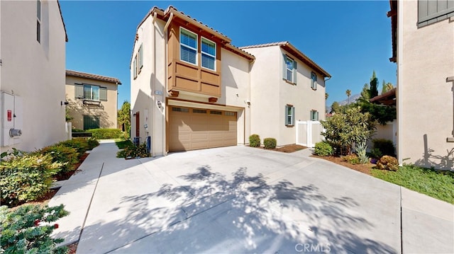 view of front facade featuring stucco siding, an attached garage, and driveway