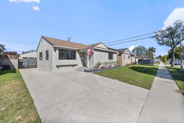 view of front of home featuring stucco siding, concrete driveway, central AC, fence, and a front lawn