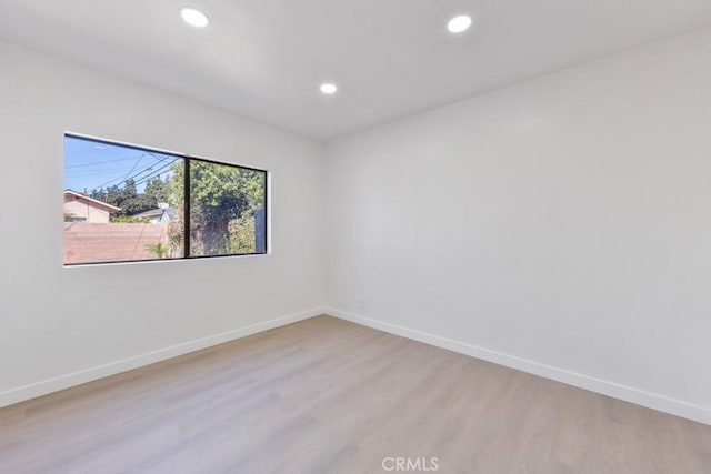 spare room with light wood-style floors, recessed lighting, and baseboards