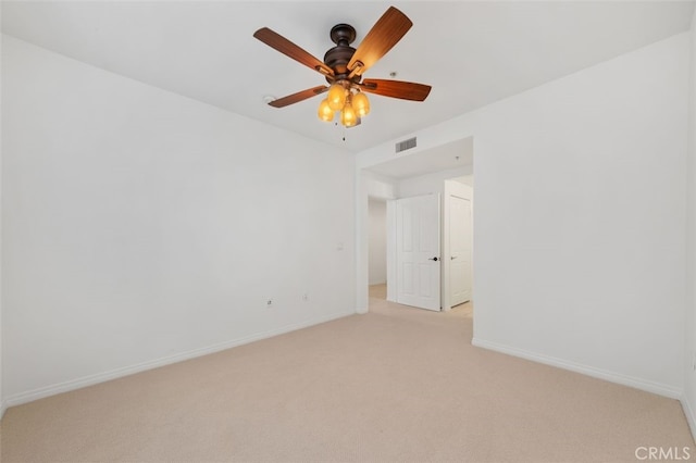 unfurnished room featuring visible vents, light carpet, baseboards, and a ceiling fan